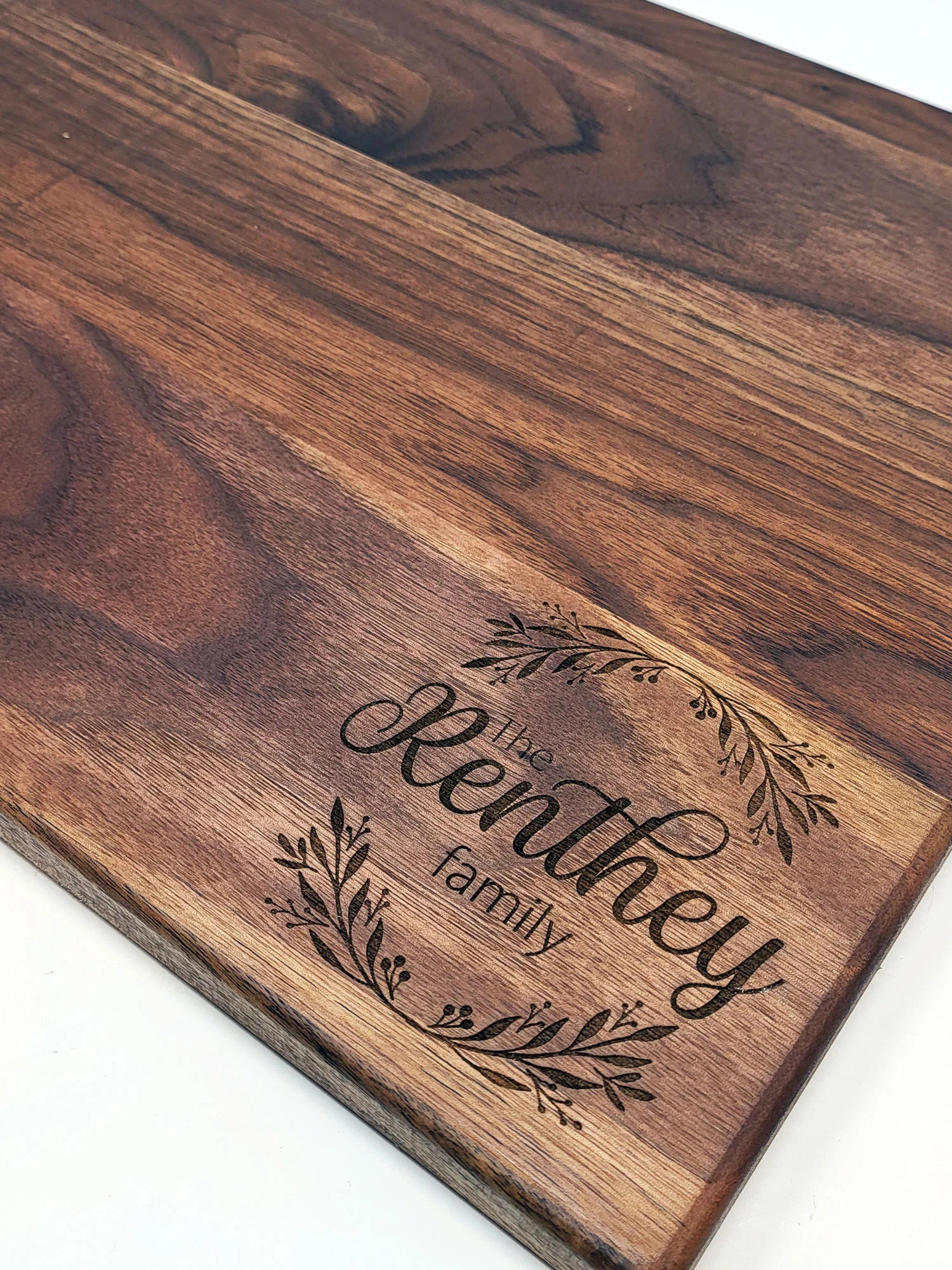 Premium engraved walnut cutting board with family name – Stitch & Flame